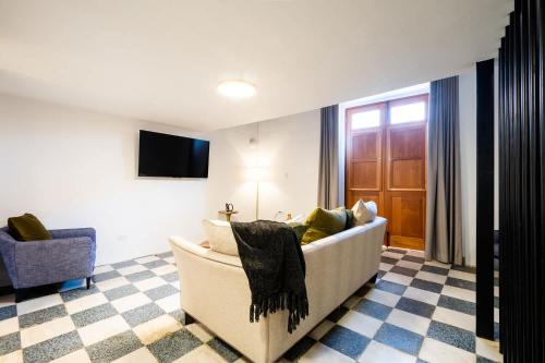 a living room with a couch and a tv at Casa Las Ruinas by Stay with Bear in San Juan