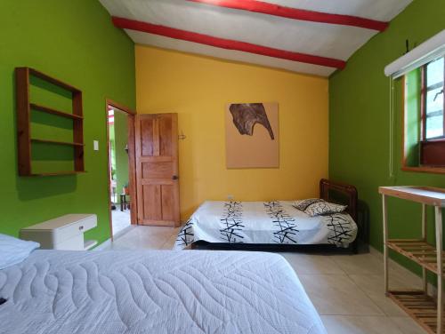 a bedroom with two beds and green walls at Casa Campestre Buenavista, espacio natural in Ráquira