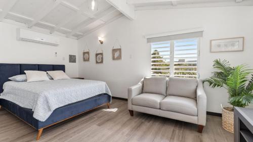 a bedroom with a bed and a chair at Danielas Beachfront Studio in Rincon