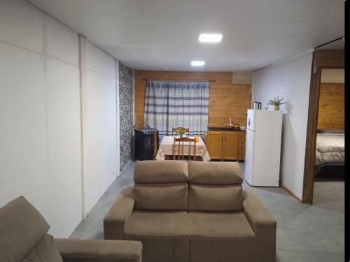 a living room with a couch and a refrigerator at Casa céntrica cómoda in Chuí