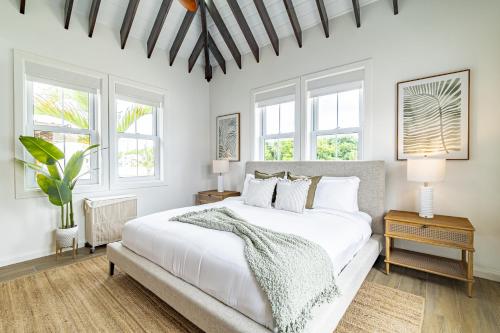 - une chambre blanche avec un grand lit et des fenêtres dans l'établissement Coral Reef Casa with Private Hot Tub and Pool at Mahogany Bay, à San Pedro