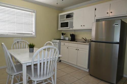 a kitchen with a table and a stainless steel refrigerator at Gulf View Waterfront Resort in Marathon