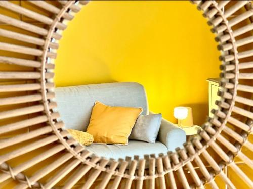 un miroir reflétant un canapé bleu dans une pièce jaune dans l'établissement Face à la plage STUDIO avec grande terrasse au calme, à Marseille