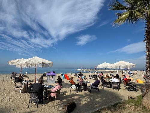 a group of people sitting at tables on the beach at Comfort Suites in Golem