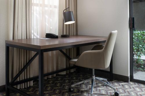 a desk with a lamp and a chair in a room at Residence Inn by Marriott San Francisco Airport San Mateo in San Mateo