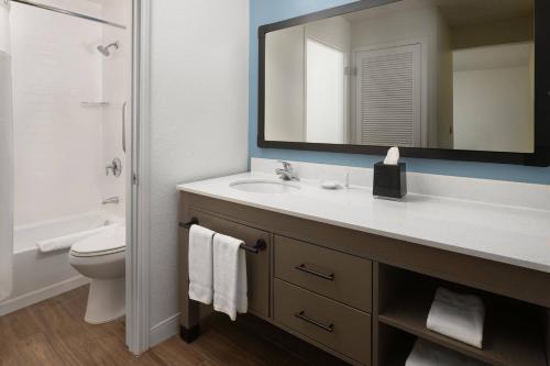 a bathroom with a sink and a toilet and a mirror at Residence Inn by Marriott San Francisco Airport San Mateo in San Mateo