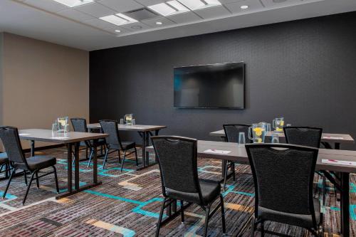 a conference room with tables and chairs and a flat screen tv at Residence Inn by Marriott Regina in Regina