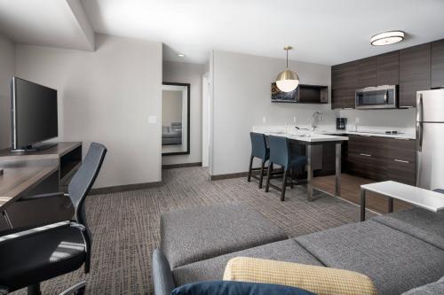 a living room with a couch and a kitchen at Residence Inn by Marriott Boulder Canyon Boulevard in Boulder