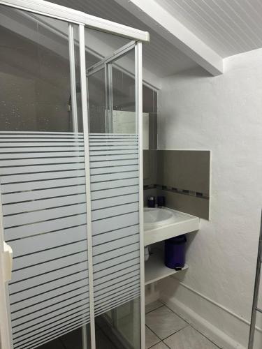 a white bathroom with a sink and a mirror at Gwada Rêves in Sainte-Anne
