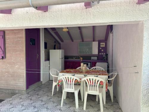 a table and chairs in a kitchen with purple walls at Gwada Rêves in Sainte-Anne