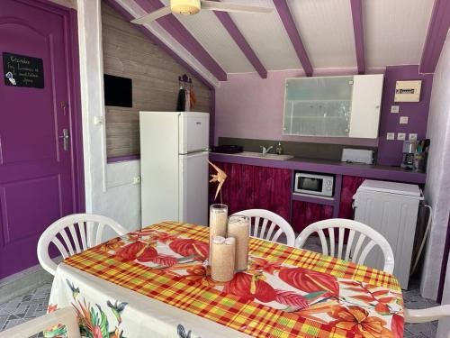 a kitchen with a table and chairs and a purple door at Gwada Rêves in Sainte-Anne