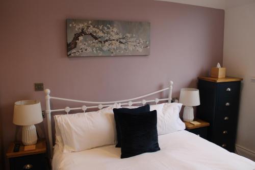 a bedroom with a white bed and two lamps at The White Lion in Ventnor