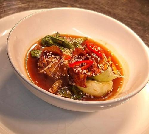 a bowl of soup with meat and vegetables on a table at The White Lion in Ventnor