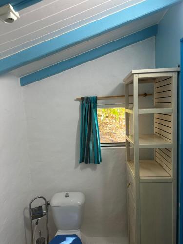 a bathroom with a white toilet and a window at Gwada Rêves in Sainte-Anne