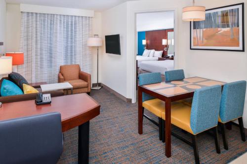 a hotel room with a dining table and a living room at Residence Inn by Marriott Harrisonburg in Harrisonburg