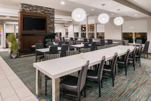a conference room with tables and chairs and a flat screen tv at Residence Inn by Marriott Harrisonburg in Harrisonburg