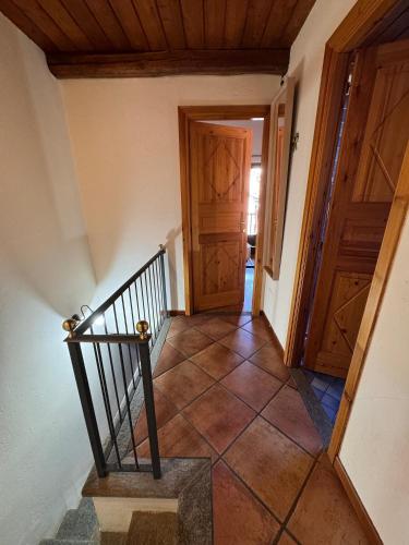 a hallway with a staircase and wooden doors at Baita Plagnol Sestriere Ski Slopes in Sestriere