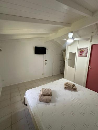 a bedroom with a bed with towels on it at Gwada Rêves in Sainte-Anne