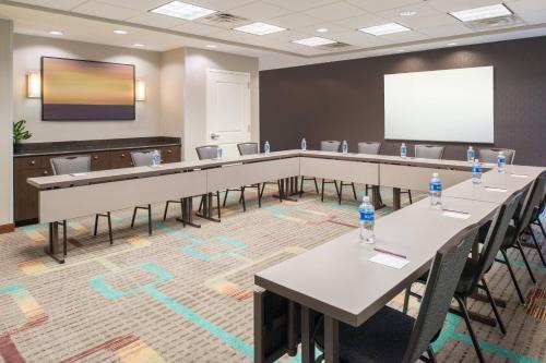 a conference room with tables and chairs and a screen at Residence Inn by Marriott Harrisonburg in Harrisonburg
