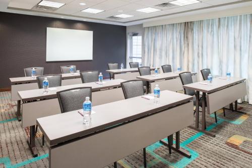 a conference room with tables and chairs and a whiteboard at Residence Inn by Marriott Harrisonburg in Harrisonburg