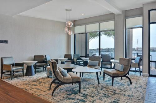 a lobby with tables and chairs and windows at Residence Inn by Marriott Fort Walton Beach in Fort Walton Beach