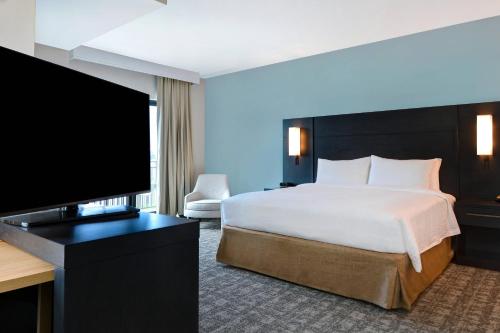 a hotel room with a bed and a flat screen tv at Residence Inn by Marriott Fort Walton Beach in Fort Walton Beach