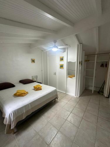 a bedroom with a bed with yellow towels on it at Gwada Rêves in Sainte-Anne