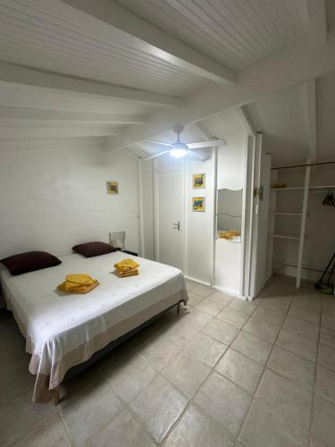 a bedroom with a bed with yellow towels on it at Gwada Rêves in Sainte-Anne