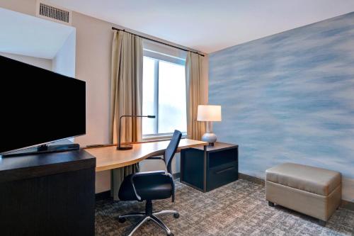 a hotel room with a desk with a computer and a tv at Residence Inn by Marriott Fort Walton Beach in Fort Walton Beach