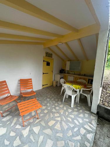 a patio with chairs and a table and a kitchen at Gwada Rêves in Sainte-Anne