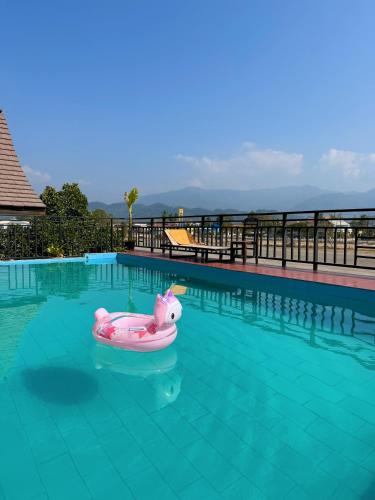 a swimming pool with a pink raft in the water at Vangvieng Sisavang Hotel in Vang Vieng