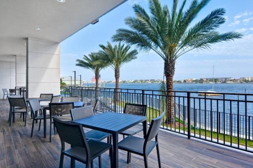 a patio with tables and chairs and a view of the water at Residence Inn by Marriott Fort Walton Beach in Fort Walton Beach