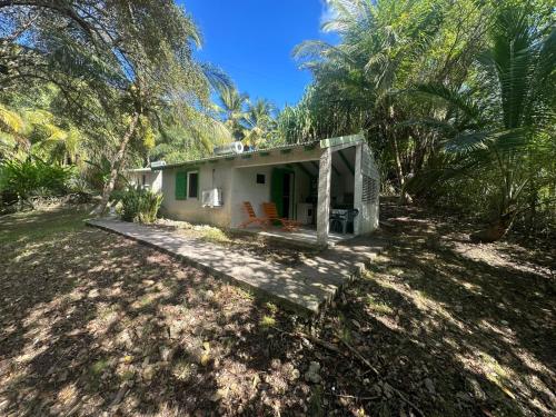 a small white house in the middle of a yard at Gwada Rêves in Sainte-Anne