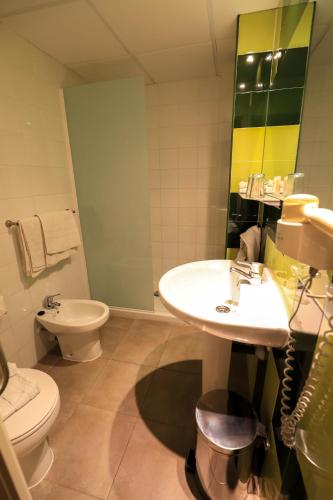 a bathroom with a sink and a toilet at Es Mitjorn Hotel in San Antonio