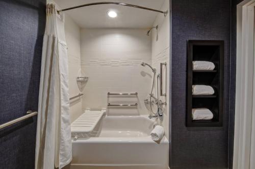 a bathroom with a white tub and a shower at Residence Inn by Marriott Tulsa Midtown in Tulsa