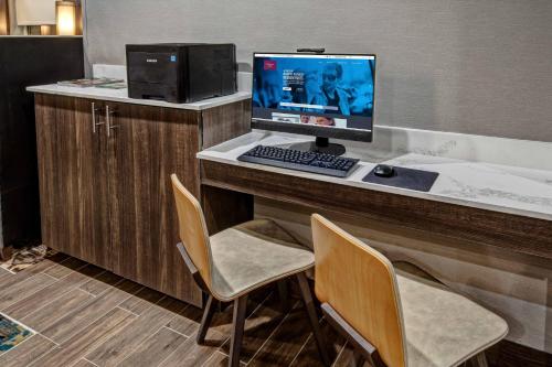a computer sitting on a desk with two chairs at Residence Inn by Marriott Tulsa Midtown in Tulsa
