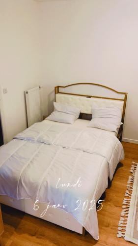 - un lit avec des draps et des oreillers blancs dans l'établissement modern and secure residence, à Romainville