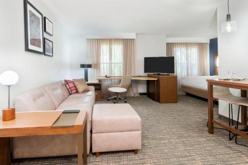 a hotel room with a couch and a bed at Residence Inn by Marriott Sarasota Bradenton in Sarasota