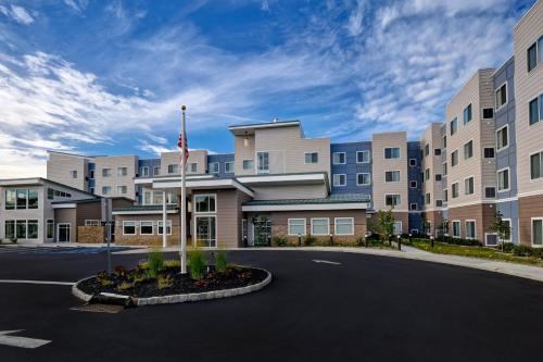 a building with a flag in the middle of a street at Residence Inn Middletown Goshen in Middletown