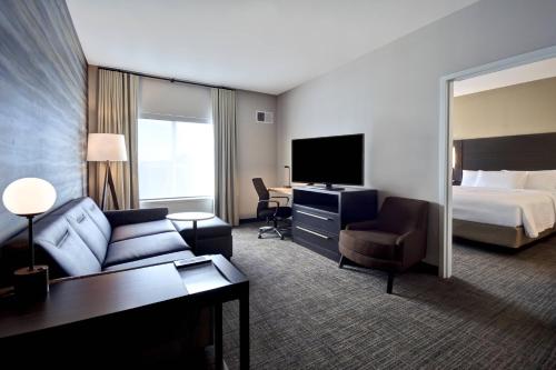 a hotel room with a bed and a living room at Residence Inn Middletown Goshen in Middletown