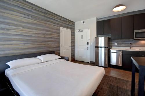 a bedroom with a large bed and a kitchen at Residence Inn Middletown Goshen in Middletown