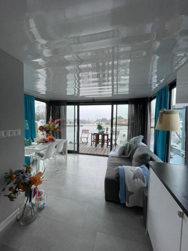 a living room with a couch and a table at The Blue Houseboat in Zwartsluis