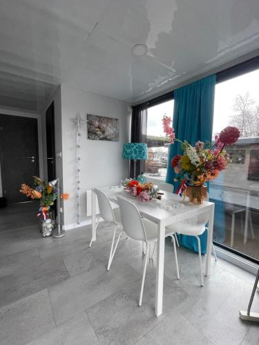 a white dining room with white tables and chairs at The Blue Houseboat in Zwartsluis