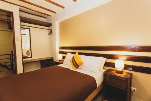 a bedroom with a large bed and a mirror at Kutimuy Lodge in Urubamba