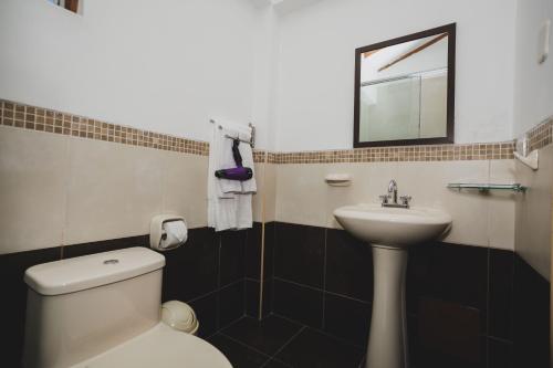 a bathroom with a white toilet and a sink at Kutimuy Lodge in Urubamba