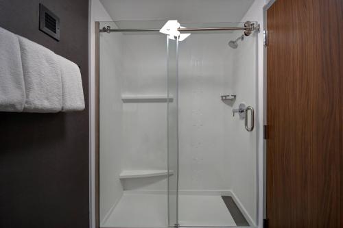 a shower with a glass door in a bathroom at Courtyard by Marriott Cincinnati Airport in Erlanger