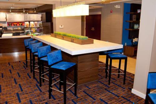 a kitchen with a counter with blue bar stools at Courtyard by Marriott Cincinnati Airport in Erlanger