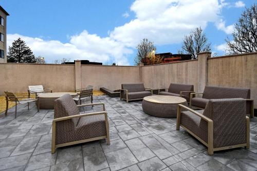a patio with chairs and tables and a fence at Courtyard by Marriott Cincinnati Airport in Erlanger