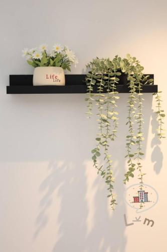 a black shelf with flowers and plants on it at The Central Pattaya High Floor, Pattaya City in Pattaya Central