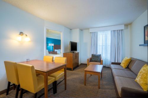 a living room with a couch and a table in a room at Residence Inn by Marriott Salisbury in Salisbury